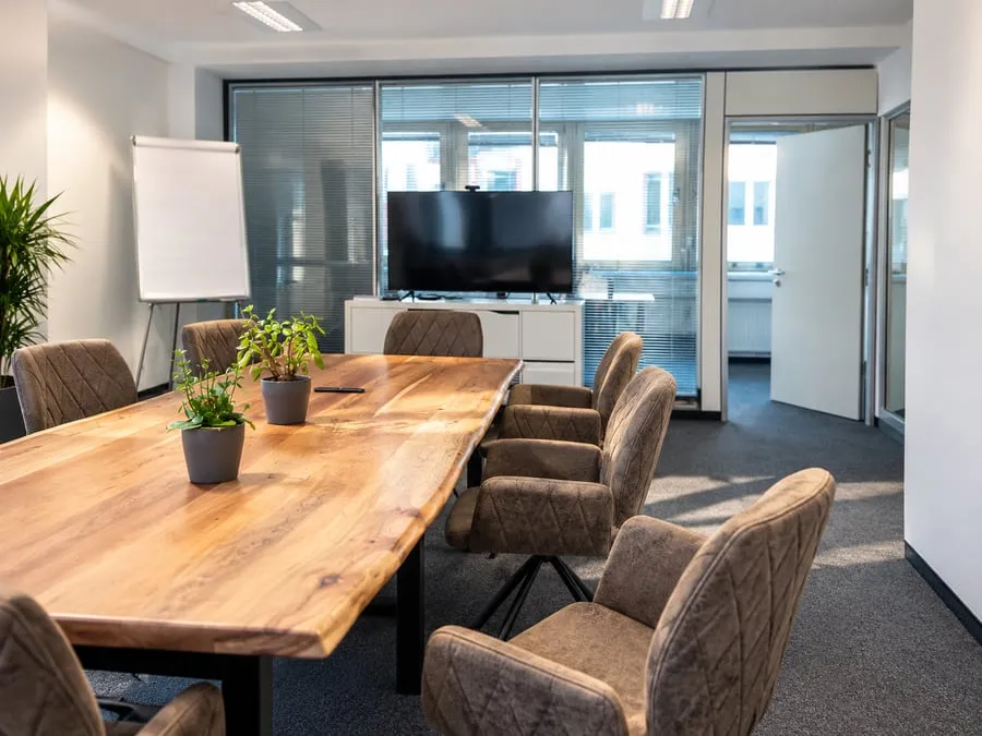 Meeting room with a wooden table, flipchart and screen