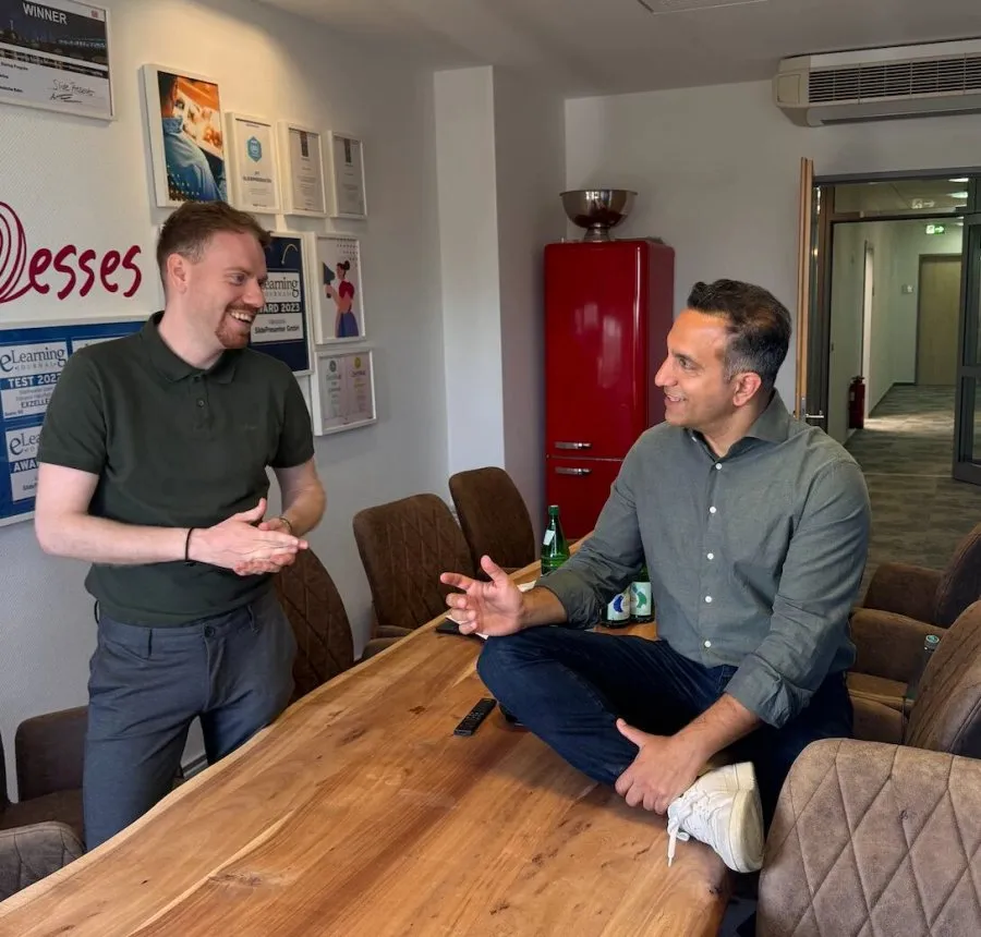 Two colleagues in a relaxed conversation in the meeting room