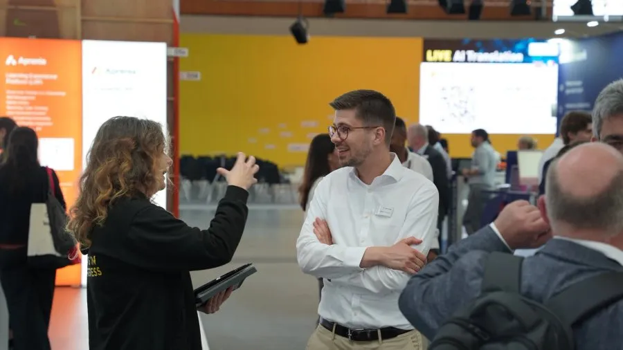 Omnora at a trade fair stand talking with a visitor